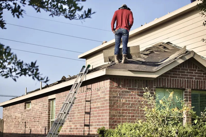 Professional roofer working on a residential roof in River District
